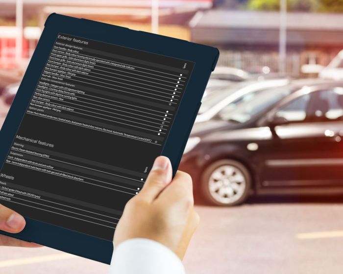 Man using tablet pc against view of row new car