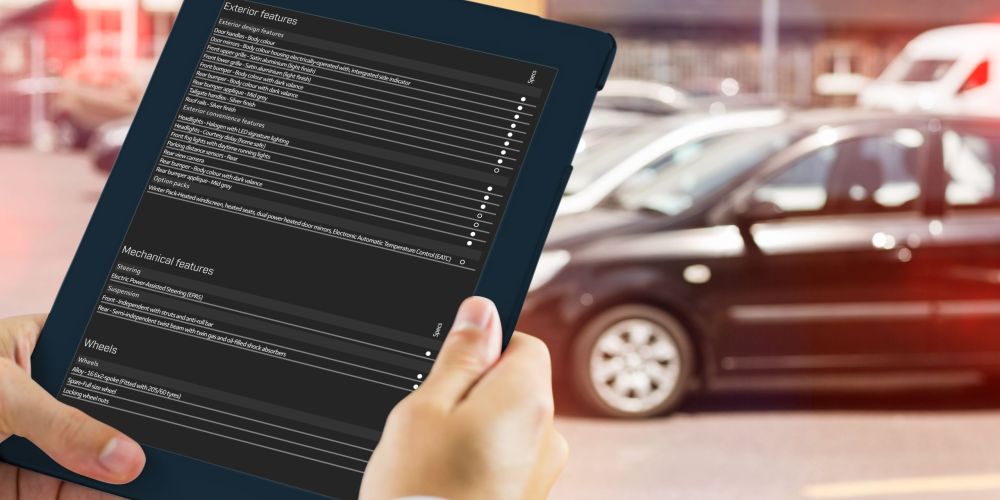 Man using tablet pc against view of row new car