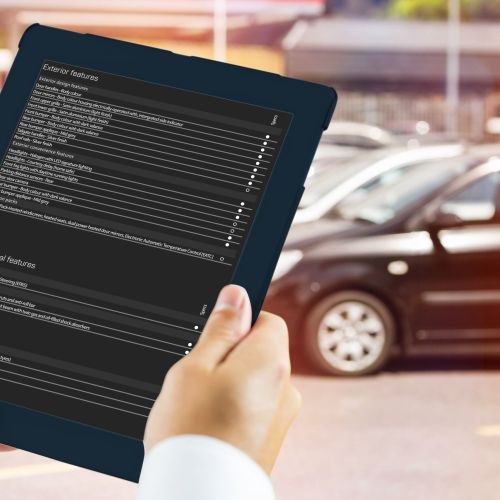 Man using tablet pc against view of row new car