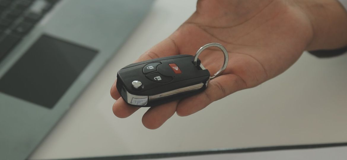 Young man receives a key from car salesman. After agreeing to a