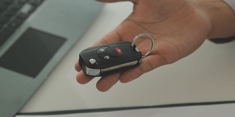 Young man receives a key from car salesman. After agreeing to a